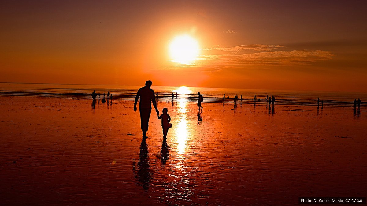 Father's Day 2027 in South Africa: Date and Is It a Public Holiday? A father and his young child walking hand in hand on a beach at sunset
